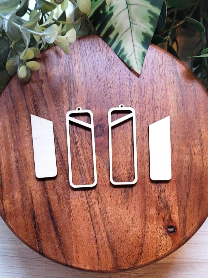 Image shows four pieces of wood, two  hollow rectangles and two solid rectangles that fit together to create earrings.