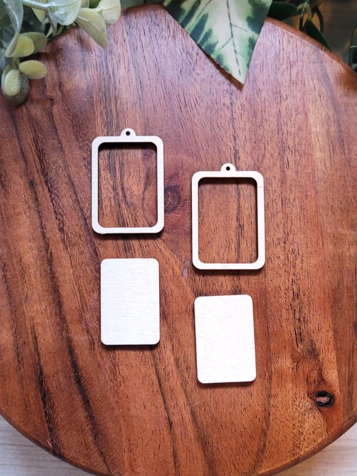 Image shows four pieces of wood, two hollow rectangles and two solid rectangles that fit together to create earrings.